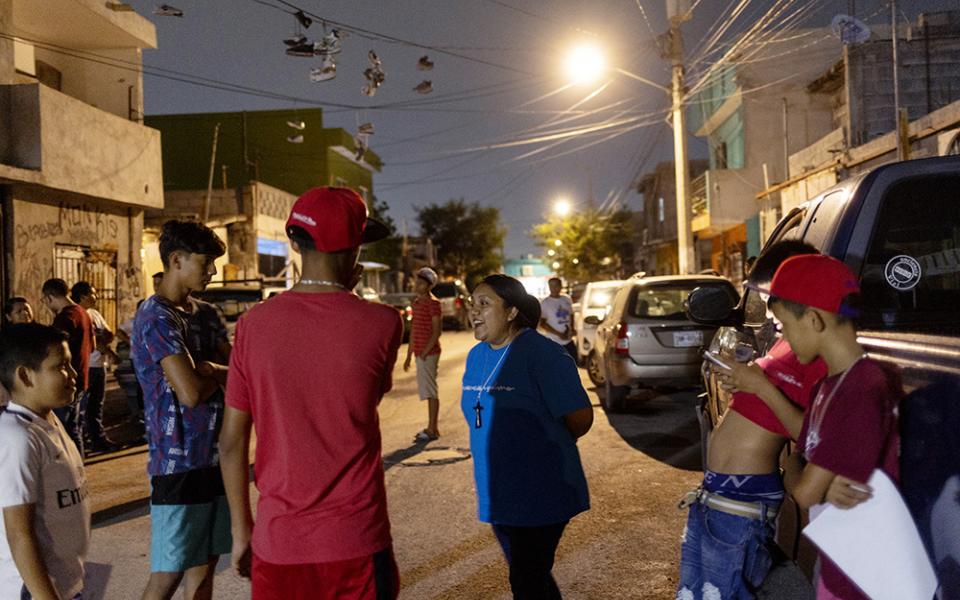 Sr. Sandra López García chats with Los Monckis youth gang members during one of her team's weekly visits to their hangout in Monterrey, Mexico, in May. (Nuri Vallbona)