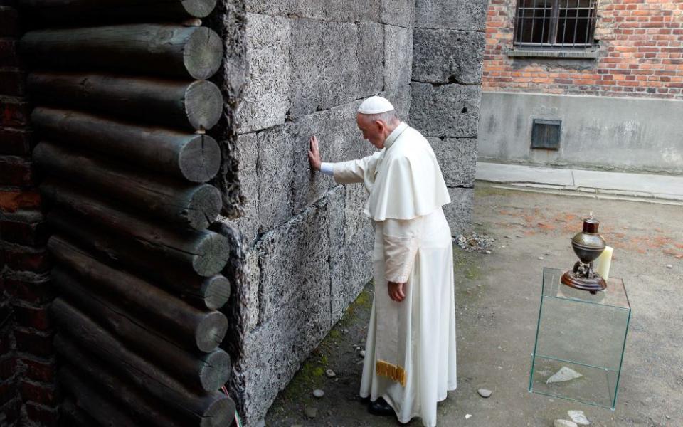 Pope Francis touches the death wall at the Auschwitz Nazi death camp in Oswiecim, Poland, in this July 29, 2016, file photo.