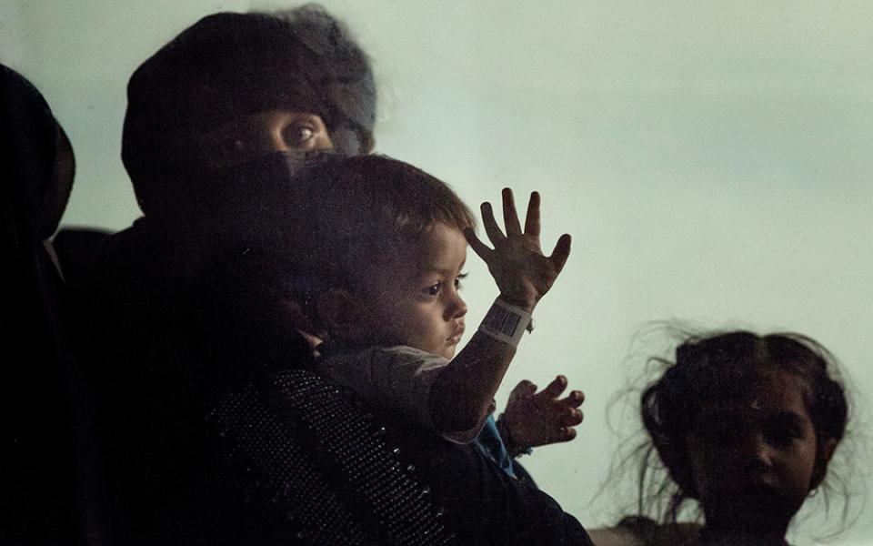 Families evacuated from Kabul, Afghanistan, sit in a bus after they arrived at Washington Dulles International Airport, in Chantilly, Va., Aug. 31, 2021. Commonwealth Catholic Charities in Virginia is among local Catholic Charities agencies that have challenged the federal government's abrupt suspension of the refugee resettlement program on Jan. 24, 2025. (AP/Gemunu Amarasinghe)