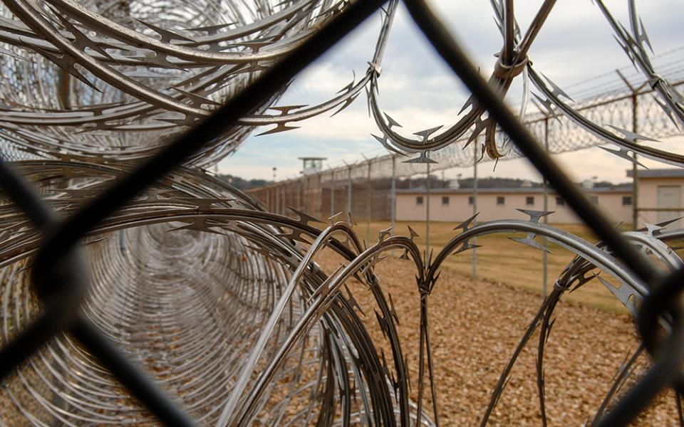 Razor wire and a watchtower are seen at Louisiana State Penitentiary at Angola in 2007. Two inmates there, half-brothers Bernard Joseph and Marcus Hamilton, are serving life terms for murdering Josephite Fr. Patrick McCarthy in 1988. They accuse McCarthy and another Josephite priest of sexual abuse. (Newscom/ZUMA Press/Robin Nelson)