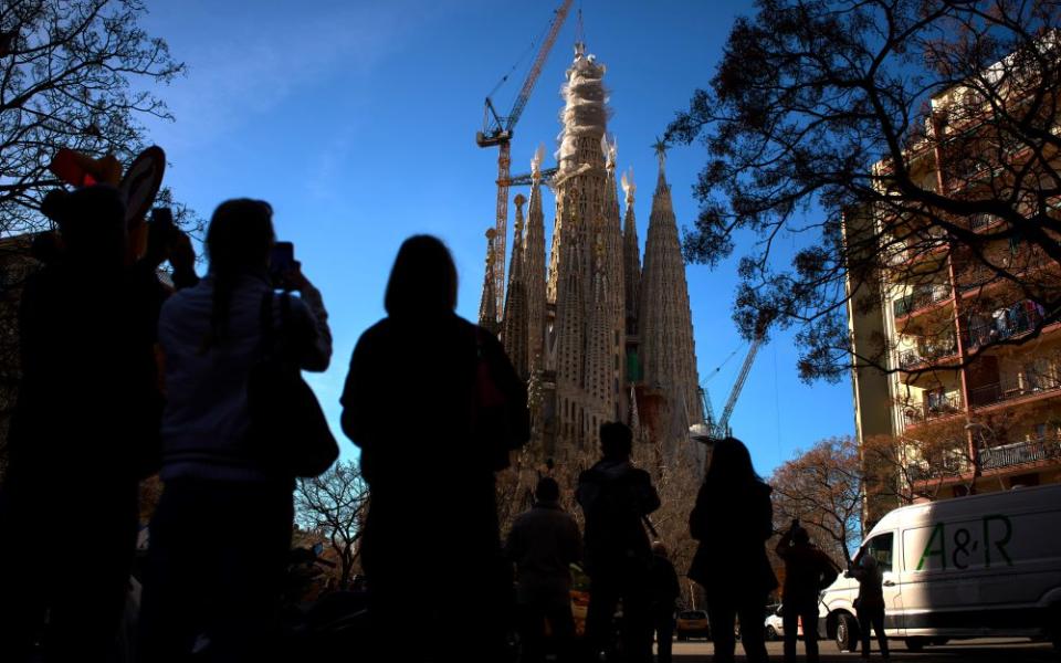 People watch as a crane lifts the upper arm of the cross onto the Tower of Jesus Christ at the Sagrada Familia in Barcelona, Spain, Feb. 20, reaching the basilica's maximum height of 172.5 meters (566 feet). (AP/Emilio Morenatti)