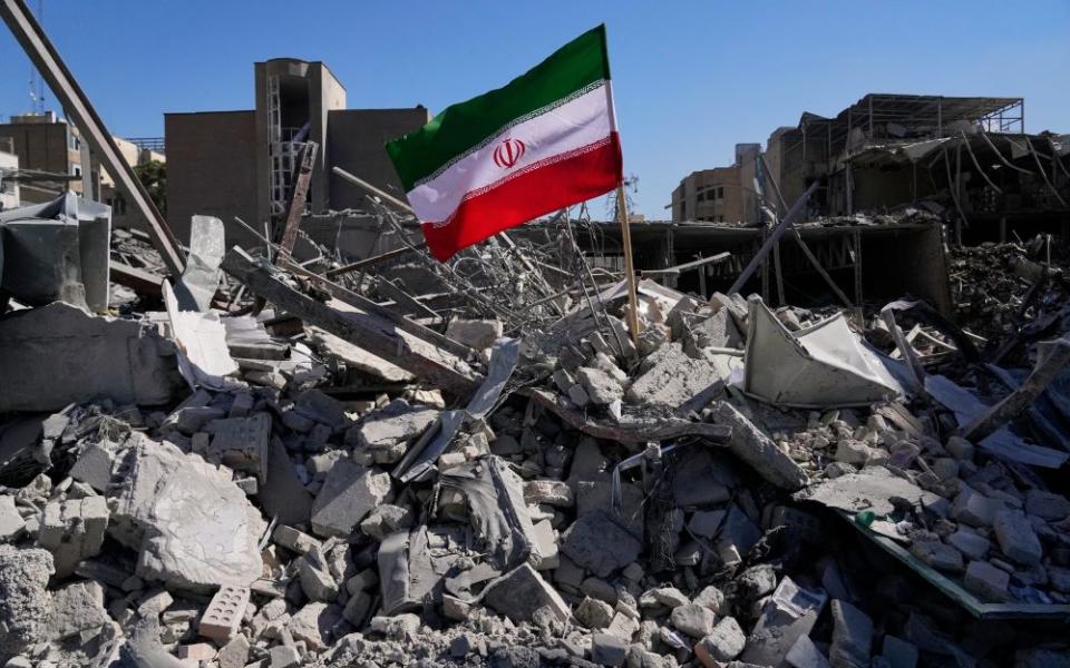 An Iranian flag is placed among the ruins of a police station struck March 2 during the U.S.-Israeli military campaign in Tehran, Iran, March 3. (AP/Vahid Salemi)