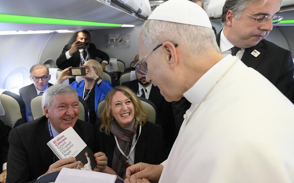 2 Elisabetta Piqué and Gerard O'Connell give a Spanish-language edition of their book, The Election of Pope Leo XIV: The Last Surprise of Pope Francis, to Leo during a flight from Rome to Ankara Nov. 27, 2025. (Courtesy of Gerard O'Connell and Elisabetta Piqué)