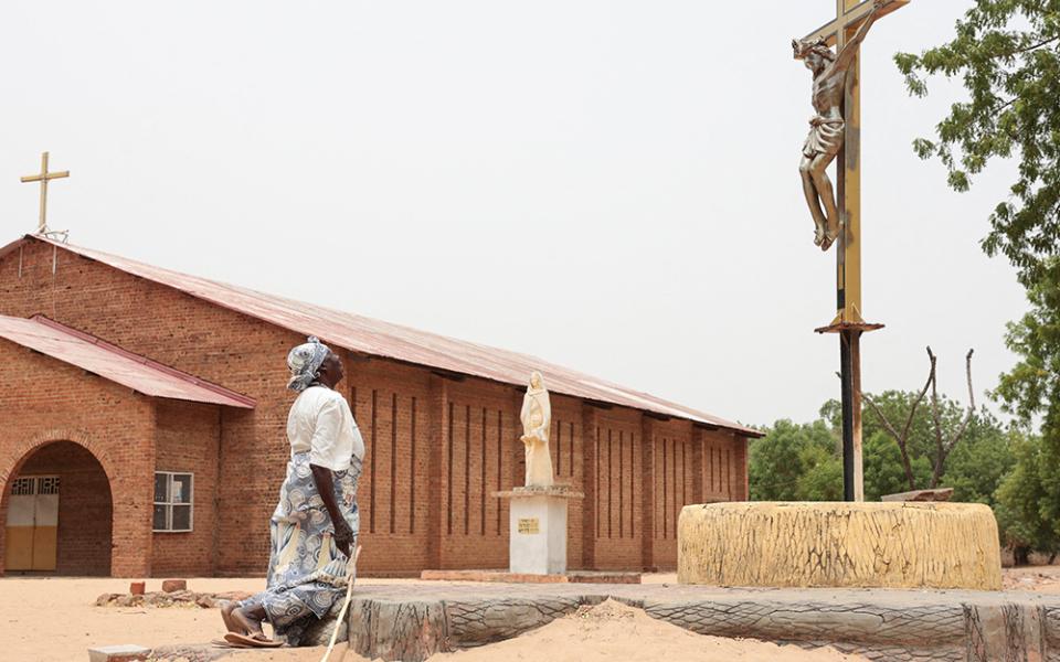 A Catholic worshipper kneels before a crucifix on Easter April 5, 2026, outside the Cathedral of St. Anne in Yagoua, Cameroon. (OSV News/Reuters/Desire Danga)