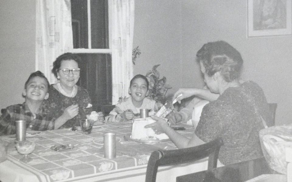 In this undated photo, Pope Leo XIV (then Robert Prevost, left) smiles while his mother (back to the camera) cuts a birthday cake in what his brother (right) guessed was the pope's ninth birthday, at the family home in the Chicago suburb of Dolton. (OSV News/Prevost family)