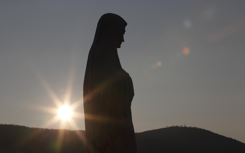 The sun sets behind a statue of Mary on Apparition Hill in Medjugorje, Bosnia-Herzegovina, in this Feb. 26, 2011, file photo. (CNS/Paul Haring)