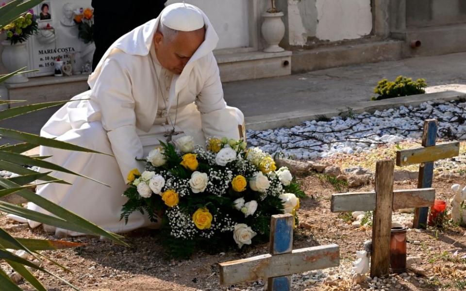 Pope Leo XIV pays tribute at the cemetery and on little Joussef's grave, in Lampedusa, Sicily, southern Italy, Saturday, July 4, 2026, during a one-day pastoral visit to an island that has become a symbol of the risks faced by migrants trying to reach Europe by sea. (Pool photo/Ciro Fusco, via AP)