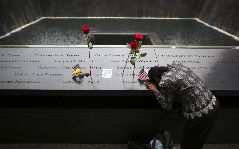 A woman grieves at the inscription of her late husband's name at the national 9/11 Memorial and Museum in New York City Sept. 11, 2014. (OSV News/Reuters/Chang Lee)