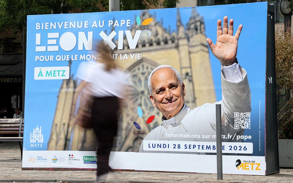 A woman walks past a poster in front of the train station in Metz, France, Sept. 9, 2026, welcoming Pope Leo XIV ahead of his visit in the northeastern French city. (OSV News/Reuters/Ardee Napolitano)