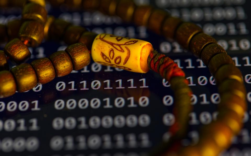 Prayer beads are photographed over a screen displaying binary code in Phoenix, Friday May 8, 2026. (AP photo/Dario Lopez-Mills)