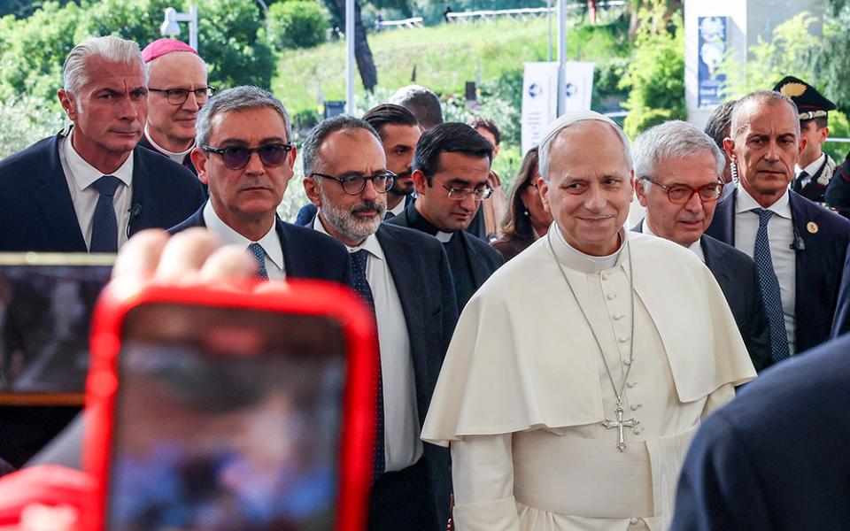 Pope Leo XIV smiles as a person takes a cellphone photo as the pontiff arrives at Rome's Gemelli Hospital Oct. 13, 2026, ahead of his surgery that afternoon. (OSV News/Reuters/Ciro De Luca)