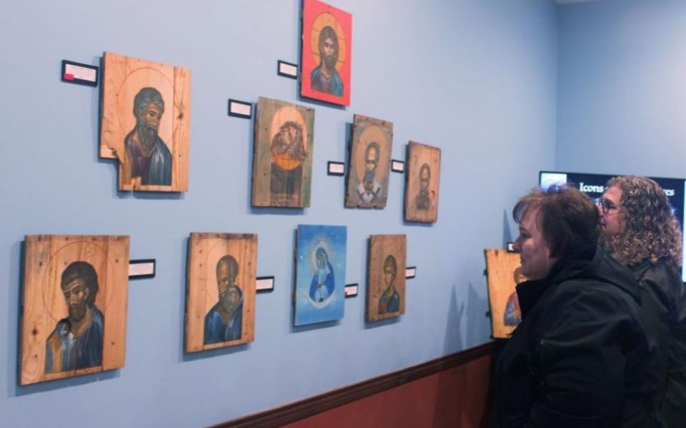 Attendees look at the "Icons on Ammo Boxes Exhibit," part of a fundraising event for Ukraine at Annunciation Byzantine Catholic Church in Homer Glen, Illinois, March 31. The event was sponsored by the parish, Rebuild Ukraine and CNEWA. (CNS/Laura Ieraci)