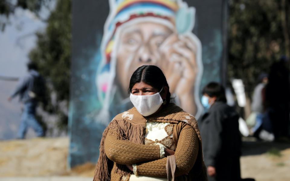 An Aymara woman wearing a protective mask stands at the blockade point set up by supporters of former President Evo Morales in El Alto, Bolivia, Aug. 10, when protesters were demanding quick presidential elections, postponed multiple times due to the COVI