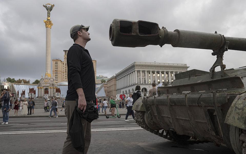 People visit an avenue where burned-out and captured Russian tanks and infantry carriers have been displayed in downtown Kyiv, Ukraine, Aug. 20. (AP/Andrew Kravchenko)