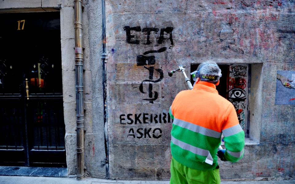 A municipal worker in Bilbao, Spain, on May 5 removes graffiti reading, "ETA, thanks," two days after the militant Basque separatist group ETA announced it had completely disbanded. (Newscom/Reuters/Vincent West)