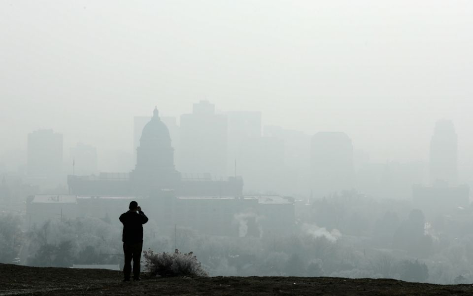 A man stops to take a picture of the Utah State Capitol and buildings that are shrouded in smog in downtown Salt Lake City Dec. 12, 2017. (CNS/Reuters/George Frey)
