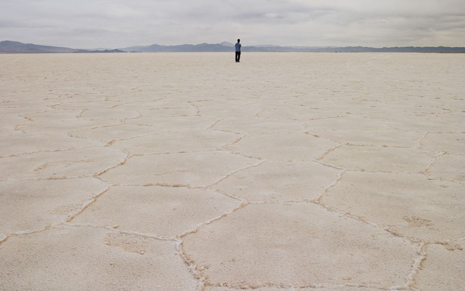 A person stands on the salt flat Salar de Arizaro, in Salta province, Argentina. In Salta and Jujuy provinces, Indigenous communities, whose livelihood depends on the extraction of salt from great deposits, oppose lithium mining, which directly impacts th