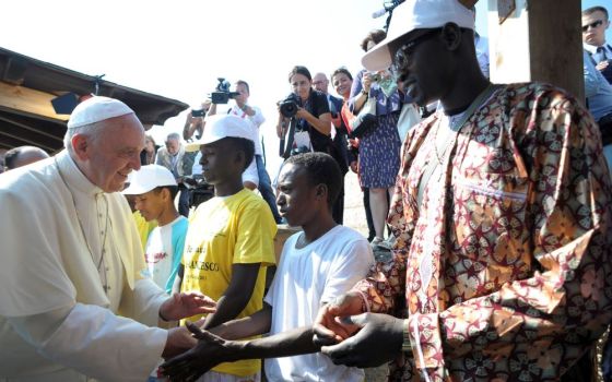 Pope Francis greets immigrants at the port in Lampedusa, Italy, July 8, 2013. There he remembered African and Middle Eastern migrants who died when their boats capsized as they were trying to reach Europe. 
