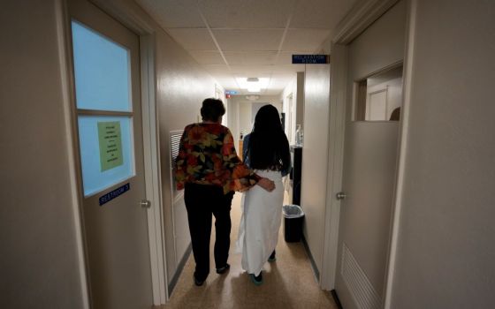 A 33-year-old mother of three from central Texas is escorted down the hall by clinic administrator Kathaleen Pittman before getting an abortion Oct. 9 at Hope Medical Group for Women in Shreveport, La. (AP/Rebecca Blackwell)