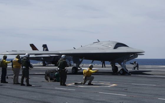 Crew members prepare May 14, 2013, to launch an X-47B pilot-less drone combat aircraft for the first time off an aircraft carrier, the USS George H. W. Bush in the Atlantic Ocean off the coast of Virginia. (CNS/Reuters/Jason Reed)