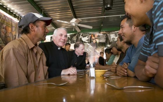 Fr. Clete Kiley (second from left), along with Salt Lake City Bishop John Wester, talks with men at the Aid Center for Deported Migrants in Nogales, Mexico, in 2014. (CNS/Nancy Wiechec)