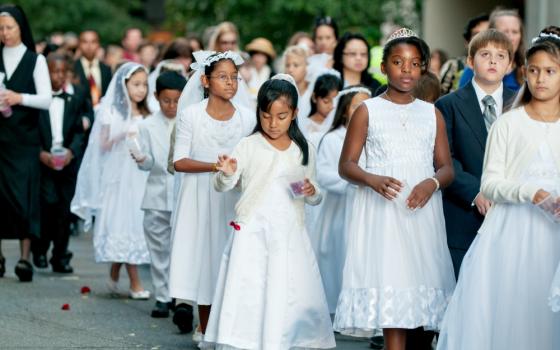 Children receiving first Communion scatter rose petals during a eucharistic procession through downtown Charlotte, North Carolina, in 2014. (CNS/Catholic News Herald/Bill Washington)