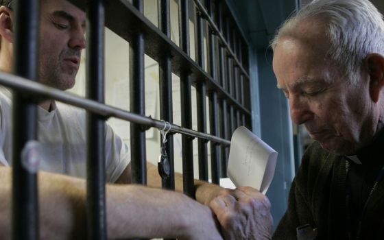 A priest prays with a death-row inmate in 2008 at Indiana State Prison in Michigan City, Indiana. One in five prisoners in the world is in a U.S. prison. (CNS/Tim Hunt, Northwest Indiana Catholic)
