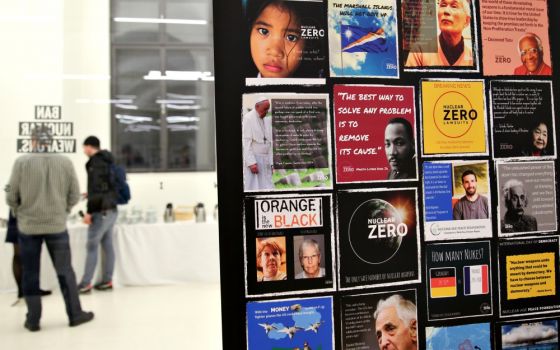 Participants talk at the International Campaign to Abolish Nuclear Weapons' Civil Society Forum in Vienna in December 2014. An image of Pope Francis was placed on a board with other leaders linked with peaceful movements. (CNS/Chaz Muth)