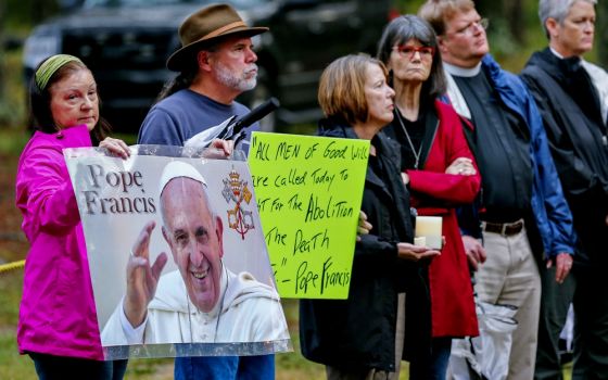 Death penalty opponents hold posters referring to Pope Francis as they stand outside the Georgia Diagnostic Prison in Jackson before the execution of Kelly Gissendaner by lethal injection in 2015. (CNS/EPA/Erik S. Lesser)