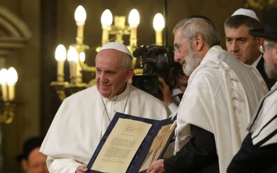 In a 2016 file photo, Pope Francis and Rabbi Riccardo Di Segni, the chief rabbi of Rome, hold a codex containing five pages of Jewish biblical commentary at the main synagogue in Rome. (CNS/Paul Haring)