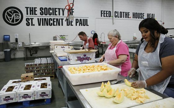 In the kitchen of the Society of St. Vincent de Paul in Phoenix in June 2016, volunteers prep food for struggling families and individuals. (CNS/Nancy Wiechec)