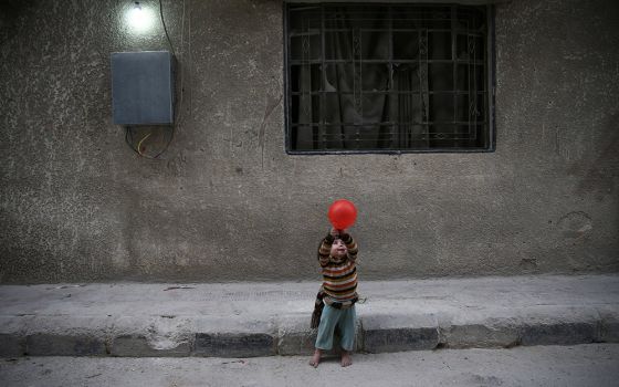 A child plays with a balloon Nov. 13, 2016, in Douma, Syria. In previous years, sanctions by the United States denied industrial parts to Syria and crippled its airline industry. (CNS/Reuters/Bassam Khabieh)