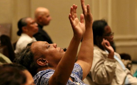 A woman prays during a Mass for solidarity and peace Aug. 24 at St. James Cathedral Basilica in Brooklyn, New York, The liturgy was held in response to the violent and deadly white supremacist demonstrations in Charlottesville, Virginia.