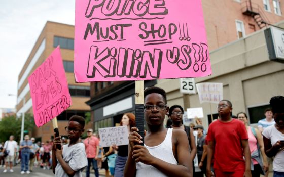 Young people hold signs during September 2017 protests after a not-guilty verdict in the murder trial of former St. Louis police officer Jason Stockley, charged with the 2011 fatal shooting of Anthony Lamar Smith, who was black. Stockley is white. (CNS)