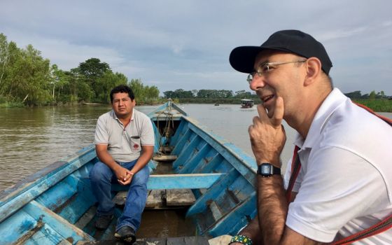 Bishop David Martínez de Aguirre Guinea travels in a boat Feb. 21 as he visits the indigenous community of Arazaire, Peru, with Caritas workers. (CNS/Stringer) 