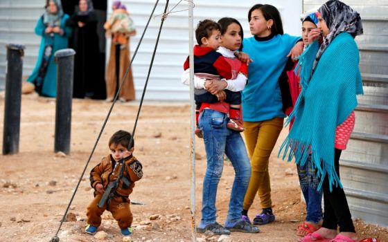 Syrian refugees wait outside their shelters in January 2018 at Zaatari camp near Mafraq, Jordan. (CNS/Reuters/Muhammad Hamed)