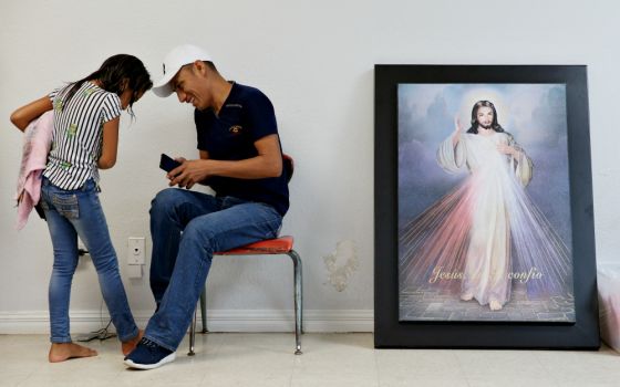 A Guatemalan immigrant and his daughter, recently released from detention through the U.S. immigration policy called "catch and release," talk with each other April 14 at the Catholic Charities relief center in McAllen, Texas. (CNS/Reuters/Loren Elliott)