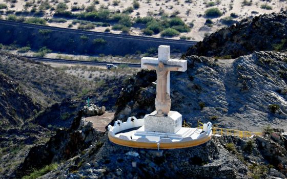 A U.S. Border Patrol truck drives along the border fence with Mexico and passes the Cristo Rey Statue on Mount Cristo in Sunland Park, New Mexico, June 18. (CNS/Reuters/Mike Blake)