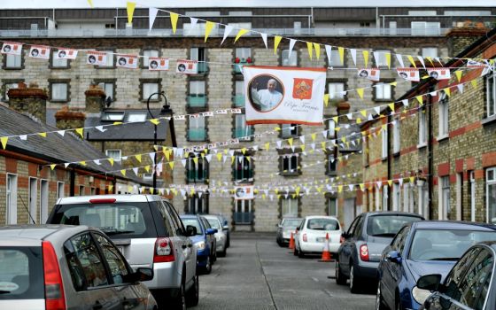 A banner with an image of Pope Francis overlooks a street lined with cars Aug. 13 in Dublin ahead of the World Meeting of Families. (CNS/Reuters/Clodagh Kilcoyne) 