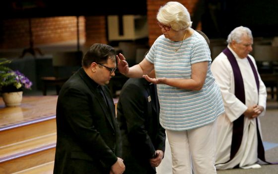 A woman administers ashes on the forehead of a priest during a prayer service for repentance and healing for clergy sexual abuse Aug. 22 at Our Lady of the Brook in Northbrook, Illinois. (CNS/Chicago Catholic/Karen Callaway)