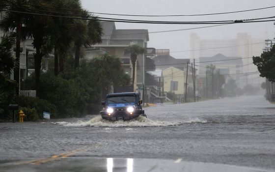 A vehicle navigates a flooded road Sept. 14, 2018, during Hurricane Florence in North Myrtle Beach, South Carolina. The next year, the coastal city of Charleston experienced 89 days of flooding, nearly one every five days. Charleston's previous record, 58