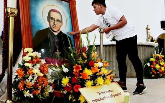 A young man touches a picture of St. Óscar Romero during an Oct. 13 Mass at the Metropolitan Cathedral in Managua, Nicaragua. The Mass was celebrated for Romero and six other new saints canonized Oct. 14 at the Vatican. (CNS/Reuters/Oswaldo Rivas)