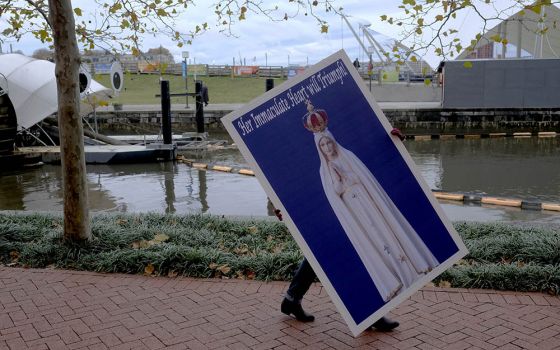 A protester carries a placard Nov. 13, 2018, for a rally sponsored by Church Militant in Baltimore during that year's fall meeting of the U.S. Conference of Catholic Bishops. (CNS/Tennessee Register/Rick Musacchio)