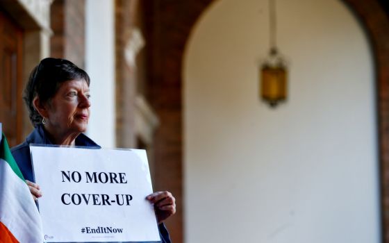 A woman demonstrates inside the headquarters of the Benedictine order in Rome Feb. 22 during a four-day meeting on the protection of minors in the church at the Vatican. (CNS/Reuters/Yara Nardi)