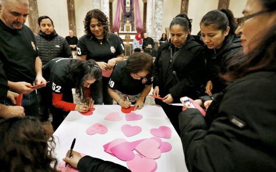 New citizens write their names on hearts to be displayed on the outside of St. Rita of Cascia Church in Bedford Park, Illinois, during a Pastoral Migratoria program March 30. (CNS/Chicago Catholic/Karen Callaway)