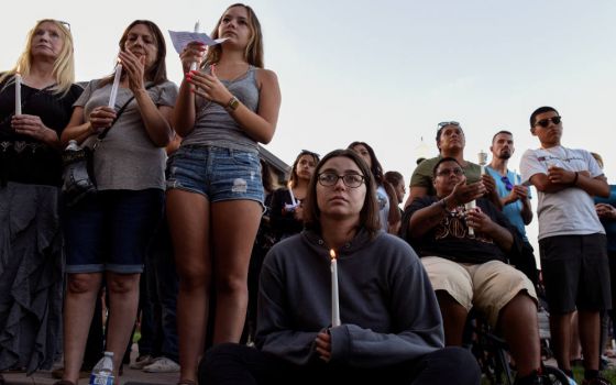 People attend a candlelight vigil outside Gilroy City Hall in California July 29, 2019, honoring those that died and were injured during a mass shooting at the Gilroy Garlic Festival a day earlier. The Diocese of San Jose held a bilingual prayer vigil Jul