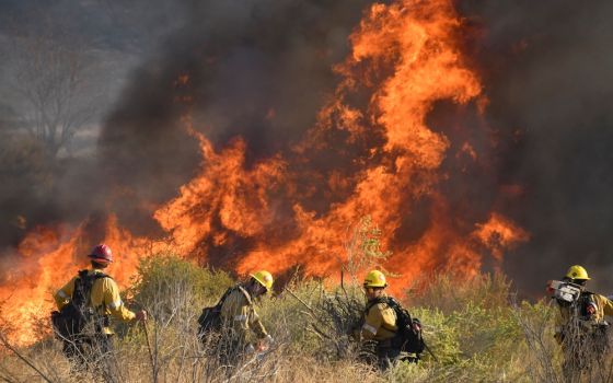 Firefighters battle a wind-driven wildfire in Canyon Country near Los Angeles in October 2019. (CNS photo/Gene Blevins, Reuters)