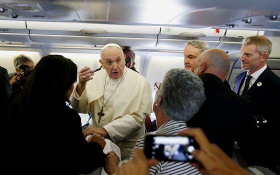 Pope Francis greets journalists aboard his flight from Rome to Maputo, Mozambique, Sept. 4. (CNS/Paul Haring)