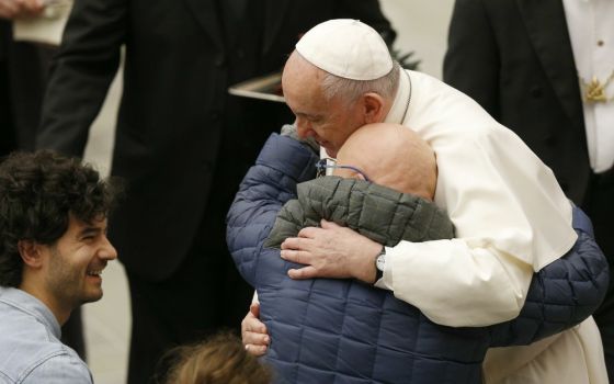 Pope Francis embraces a man as he meets disabled people during his general audience in Paul VI hall at the Vatican Jan. 8. (CNS/Paul Haring)