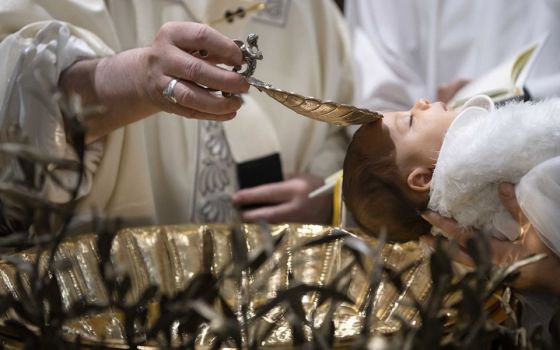 Pope Francis baptizes one of 32 babies as he celebrates Mass on the feast of the Baptism of the Lord in the Sistine Chapel Jan. 12, 2020, at the Vatican. (CNS/Vatican Media)